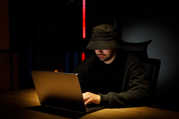 Overhead hacker working at computer and mobile phone typing text in dark room, An anonymous hacker...