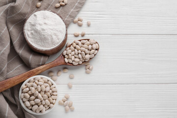 Fototapeta premium Kidney bean flour and seeds on white wooden table, flat lay. Space for text