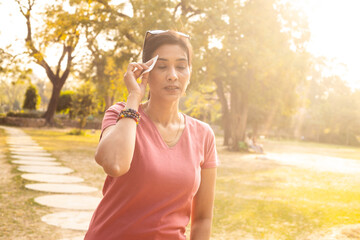 Exhausted Indian woman sweating in hot summer sunlight - heat stroke concept