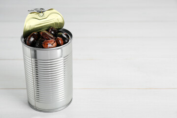 Tin can with kidney beans on white wooden table, space for text