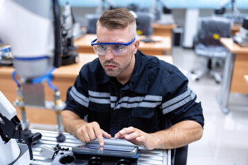 Engineer sitting in robot fabrication room quality checking robot arm hardware engineering