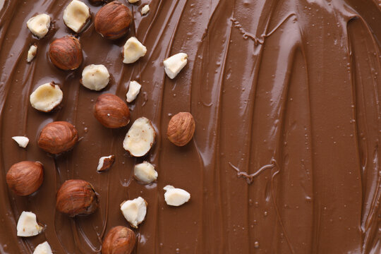 Delicious chocolate paste with nuts as background, top view