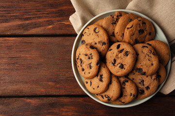 Delicious chocolate chip cookies on wooden table, top view. Space for text