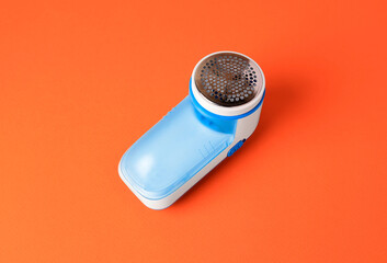 Fabric shaver on orange background, above view