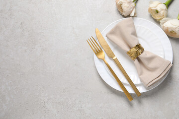 Stylish table setting with cutlery and flowers on grey background, flat lay. Space for text