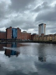 Fototapeta premium Modern buildings next to the river with reflections in the water. Salford Quays England. 