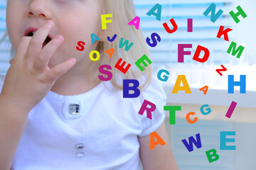 close up scattering of multi-colored different letters against background of girl 3 years old, dyslexia awareness, help children with reading, learning difficulties, human brain development concept