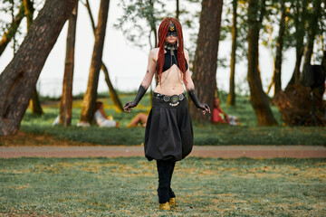 Mythological dancing girl faun on green lawn in public park outdoor art dancing event with mythological atmosphere. Girl in image of mythical creature from Narnia, female satyr dancing - obrazy, fototapety, plakaty