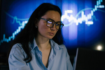 a young girl sits at a laptop, plays on the stock exchange, rejoices in the growth of shares, trading, a stockbroker