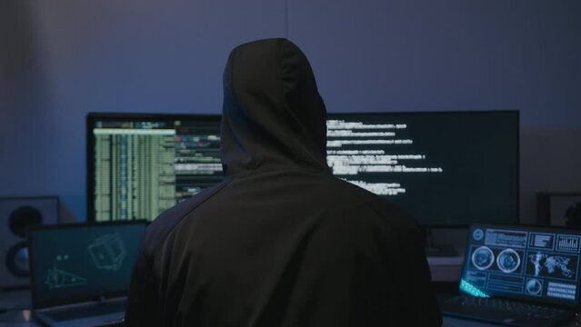 Police comes to catch anonymous hacker with brown hoodie in front of screens 