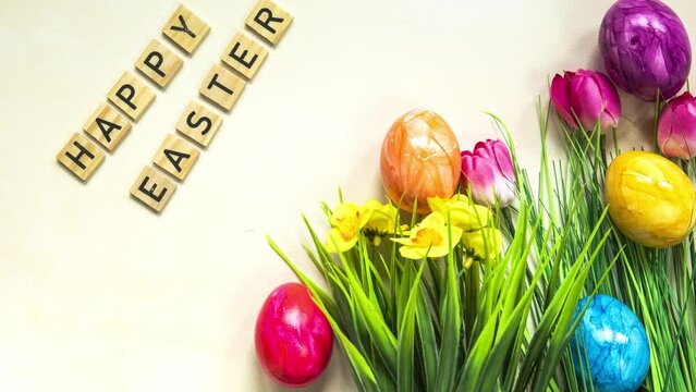 Happy Easter text with colorful paineted easter eggs in fresh green grass, Animation, colorful Easter eggs and text on a light background. Video for presentation of Happy Easter. top view