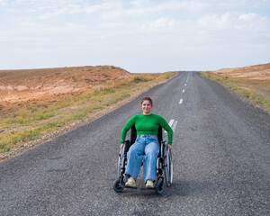 Woman in a wheelchair on a highway in the steppes. 