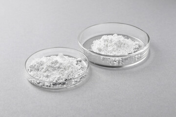 Petri dishes with calcium carbonate powder on light grey table