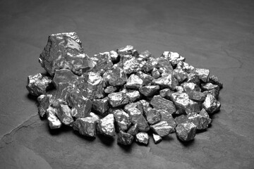 Pile of silver nuggets on black table