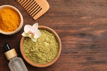 Flat lay composition with henna and turmeric powder on wooden table, space for text