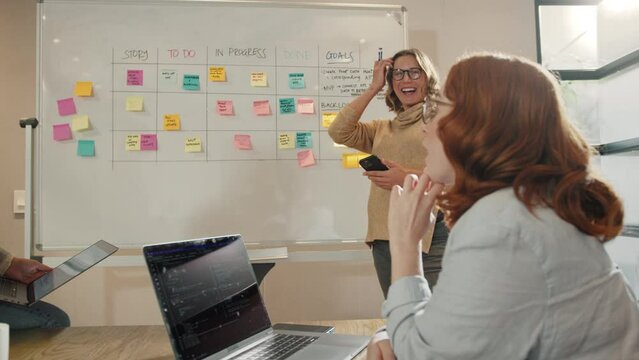 Business women having a discussion with their scrum master in a meeting. Group of creative business women brainstorming in an office. Project management using scrum process.