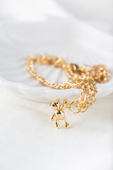 Gold chain with a bear on a light background.