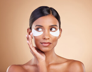 Face, skincare or Indian woman with eye patch for beauty isolated on studio background. Cosmetics or girl model with facial collagen pads or dermatology product for anti aging, hydration or wellness