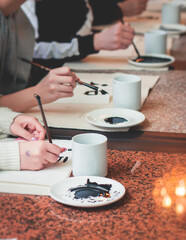 Chinese calligraphy lesson, group of kids learn and practicing traditional calligraphy in class,...