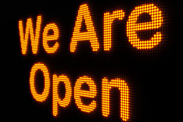 We are open. Dark LED screen with the word "We are open" in orange glowing letters. Open sign, notification icon, announcement message and commercial sign. 3D illustration