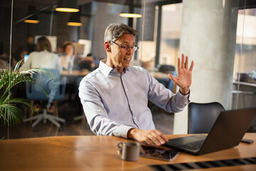 Businessman working with laptop at office. Businessman sitting at office desk working on laptop computer.