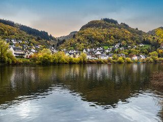 Fototapeta na wymiar Sehl village, colourful trees during autumn and reflection on Moselle river in Cochem-Zell district, Germany