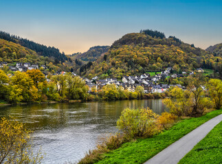 Fototapeta na wymiar Sehl village with bright colour trees, pedestrian and cyclist pathway during autumn on Moselle river in Cochem-Zell district, Germany