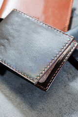 Black leather cardholder on a gray background. Handmade leather products.