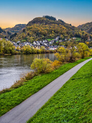 Fototapeta na wymiar Sehl village with bright colour trees, pedestrian and cyclist pathway during autumn on Moselle river in Cochem-Zell district, Germany