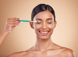 Fototapeta premium Makeup brush, eyes closed or happy woman with beauty, facial products or luxury self care on studio background. Model face or young Indian girl with eyeshadow cosmetics, glowing skincare or smile