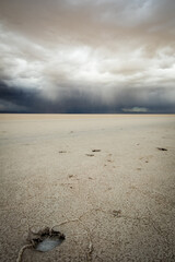 vertical of Salar de Uyuni Bolivian Tourism Salt Flat with hole on the ground and dramatic storm sky 