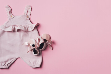 Set of baby girl clothes, shoes, accessories on pink backgroundd. Fashion newborn clothes. Flat lay, top view. Copy space