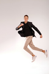 Fototapeta na wymiar Crazy young man in casual clothes jumping over studio background with big smile on his face. People success concept.