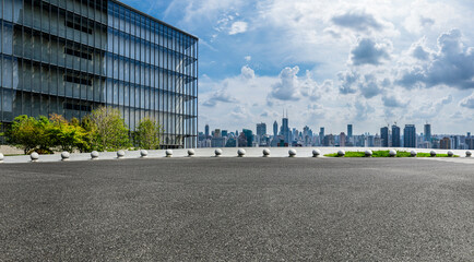 Asphalt road and glass wall with city skyline in Shanghai, China.