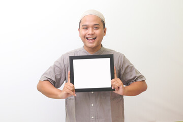 Portrait of asian muslim holding whiteboards with a wide smiling expression. isolated images in a white background.