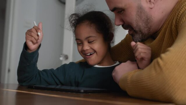 Cheerful boy with Down syndrome using digital tablet
