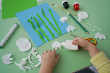 Step by step diy process. Zero waste concept. Creativity, crafting. Spring snowdrops made of cotton pads. Step 5 - glue white flowers