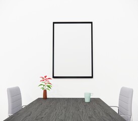 Wall frame mockup design, Two chairs on either side of a wooden table, and flower tob, tea cup on the table, one frame mockup on the wall in the middle.3D Render.