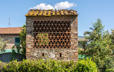 Baked brick half-timbered barn on farms in Tuscany region, nean Capannori, Lucca province,central Italy with window made of herringbone tiles for ventilation.  the facade of a stone house in Tuscany. - obrazy, fototapety, plakaty