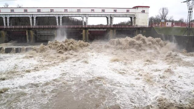 4K. Alternative energy, hydroelectric power station on the river, a view from a height of the dam system, energy production. A waterfall from a powerful current breaks through the locks of the dam.