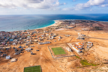 Wide aerial view on Santa Maria with the resorts on the right, African village to the left and sports field in the middle, Sal, Cape Verde Islands