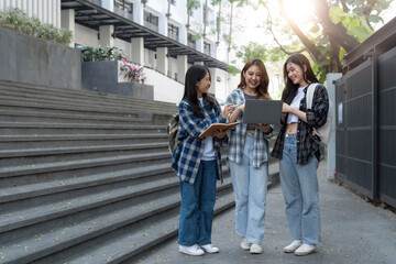 Fototapeta premium Group of Asian college student reading books and tutoring special class for exam on grass field at outdoors. Happiness and Education learning concept. Back to school concept. Teen and people theme.