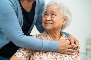 Caregiver help Asian elderly woman patient with love, care, encourage and empathy at nursing...