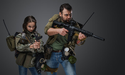 Fototapeta na wymiar Portrait of post apocalyptic girl teenager and guy with guns against grey background.