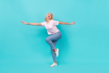 Fototapeta na wymiar Full length photo of funny crazy good mood girl dressed striped t-shirt denim pants dancing isolated on vivid turquoise color background