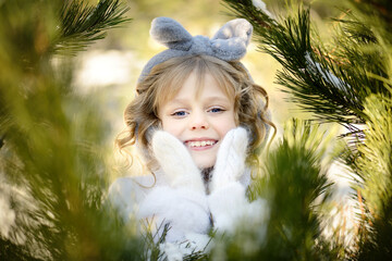 Portrait of a blue-eyed girl with golden hair blowing in the wind, smiling beautifully in a white...