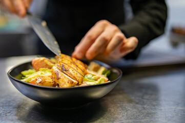 Chef cooking Caesar salad on restaurant kitchen
