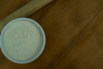 A bowl of flour on a wooden table, World Flour day and cooking concept Selective focus