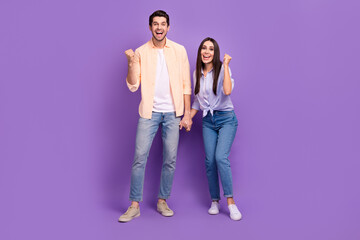 Full size portrait of two delighted satisfied people raise fists success achieve isolated on purple color background