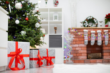 Decorated room with gifts under the Christmas tree and fireplace in background.